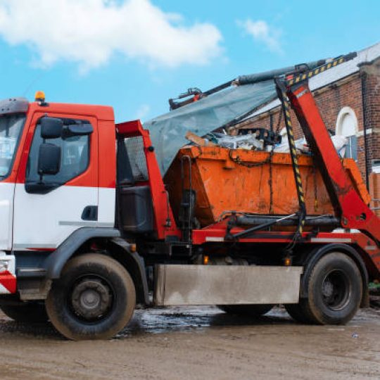 A truck self-loading industrial skip. Taking skip full of rubbish from a construction site for recycling